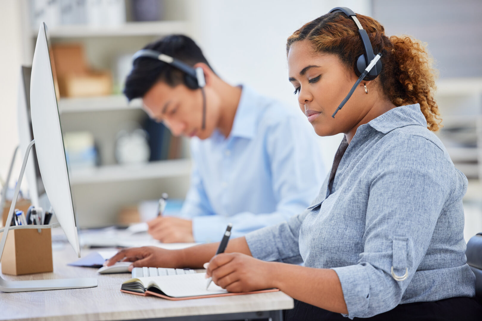 Telemarketing, business woman writing and contact us help in a office with notes at desk. Call center, African female employee and consulting of a worker with web phone support and agent advice